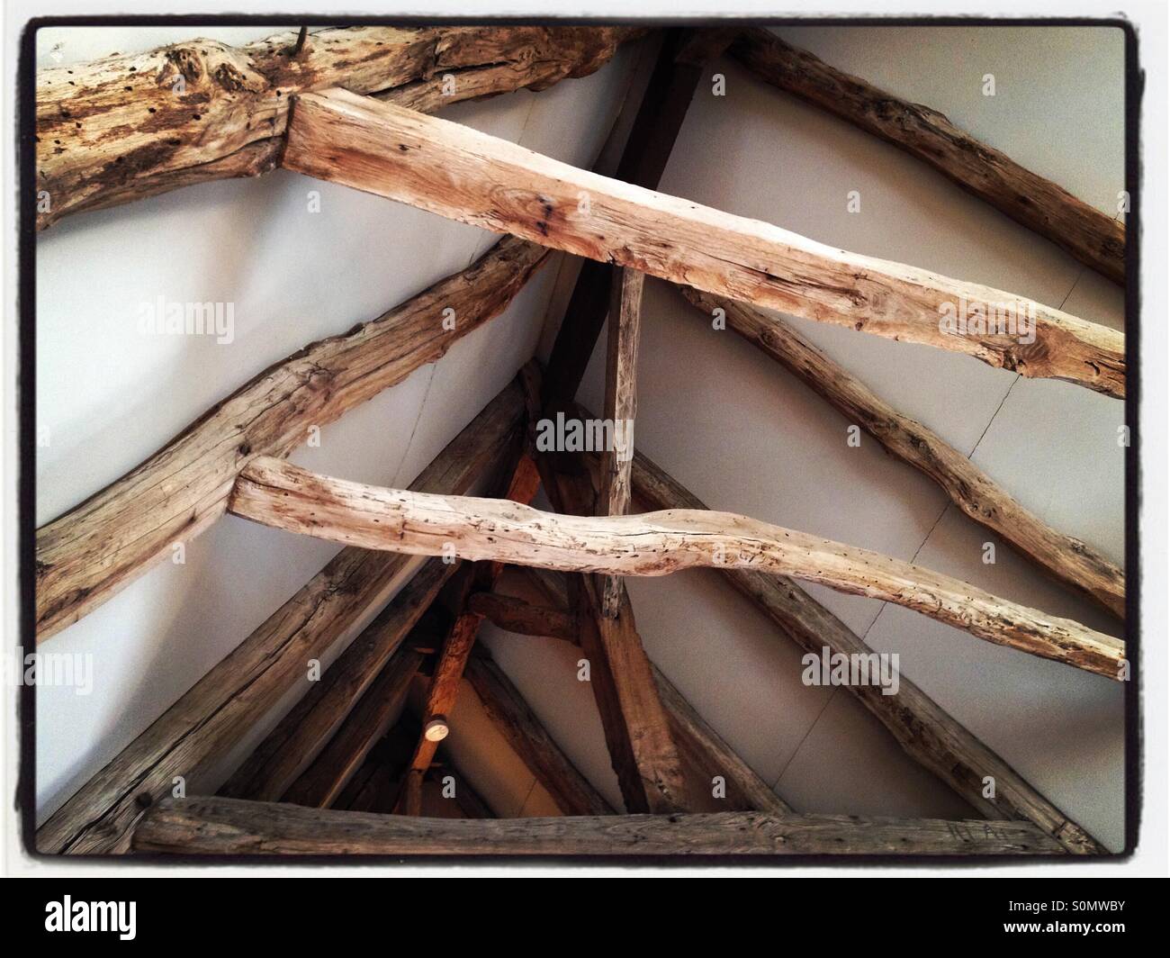 Vecchi tetti in legno esposti dopo il restauro di una casa. Foto iPhone con elaborazione in stile Instagram. - Immagine stock catturata con smartphone