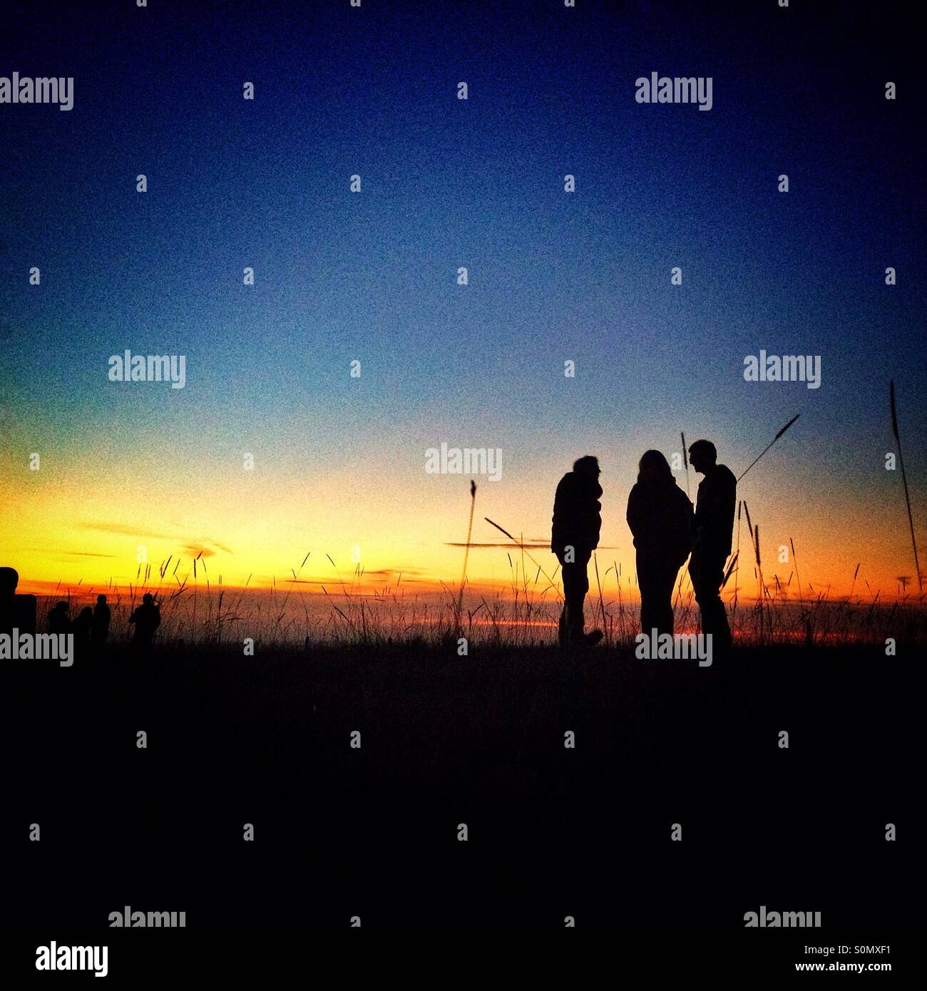 Silhouette di persone in chat al tramonto Foto Stock