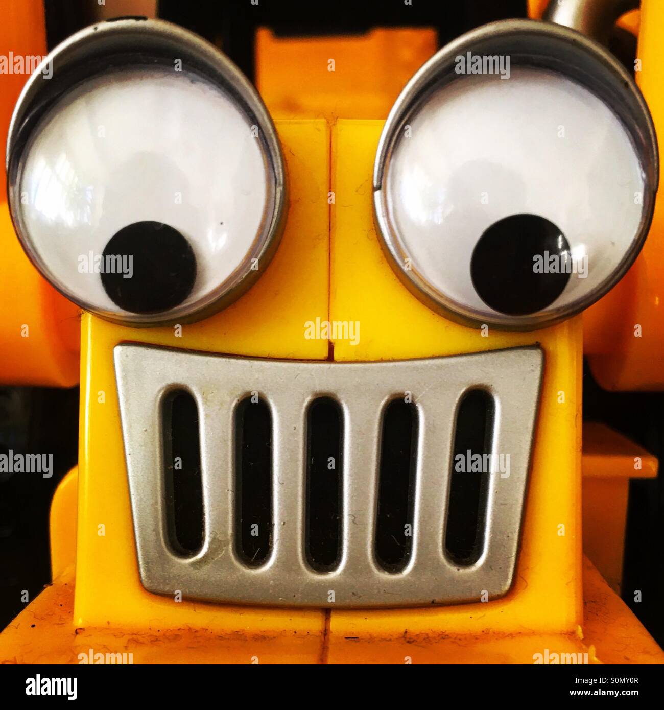 Close-up di faccia su un giallo di plastica giocattolo. Foto Stock