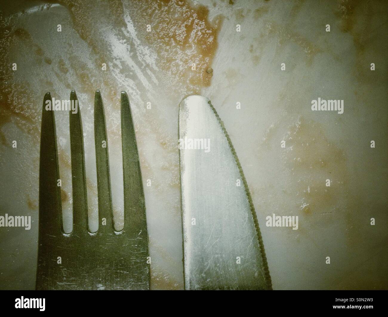 Coltello e forchetta su una piastra sporca. - Immagine stock catturata con smartphone