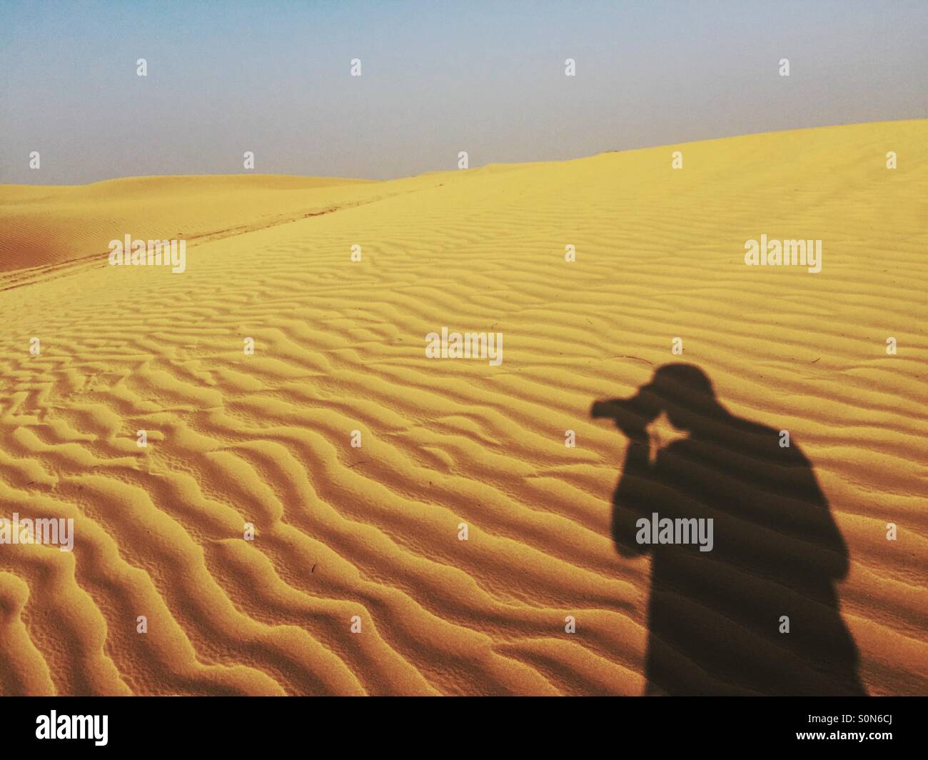 Ombra di un fotografo di scattare le foto nel deserto Dubai EMIRATI ARABI UNITI Foto Stock