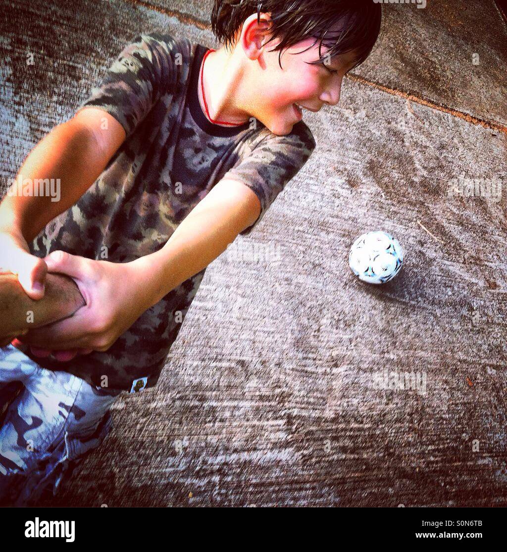 Little Boy godere il gioco del calcio Foto Stock