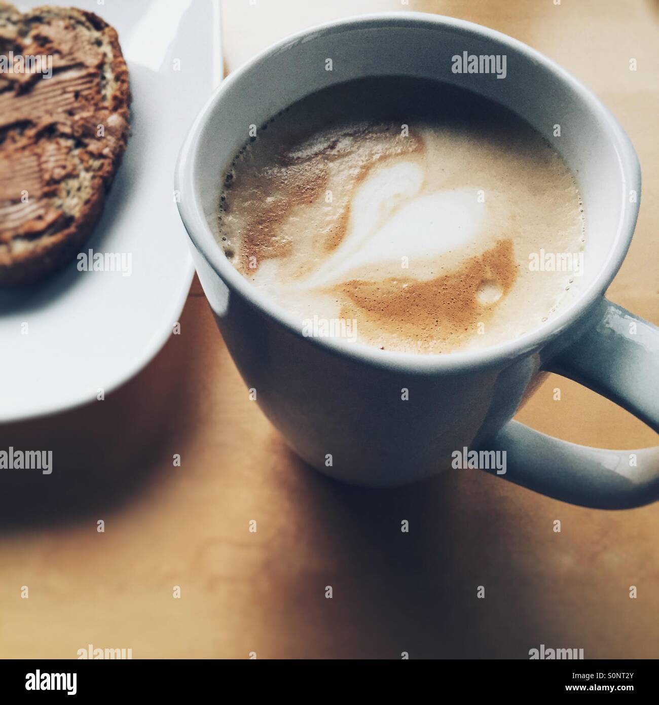 Tazza di caffè e un panino sul lato Foto Stock