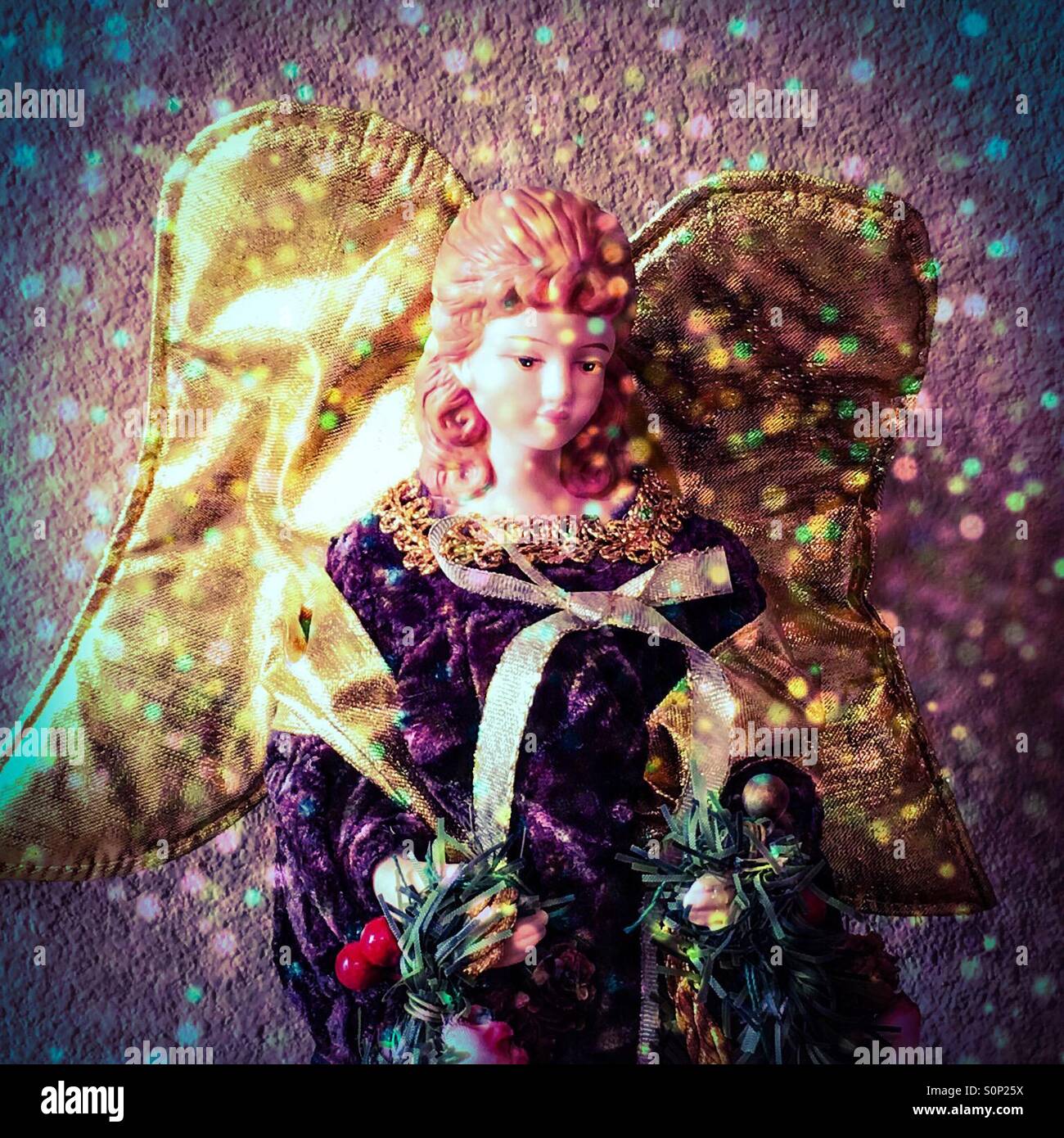 Un angelo sulla cima di un albero di Natale con un filtro di glitter aggiunto - Immagine stock catturata con smartphone