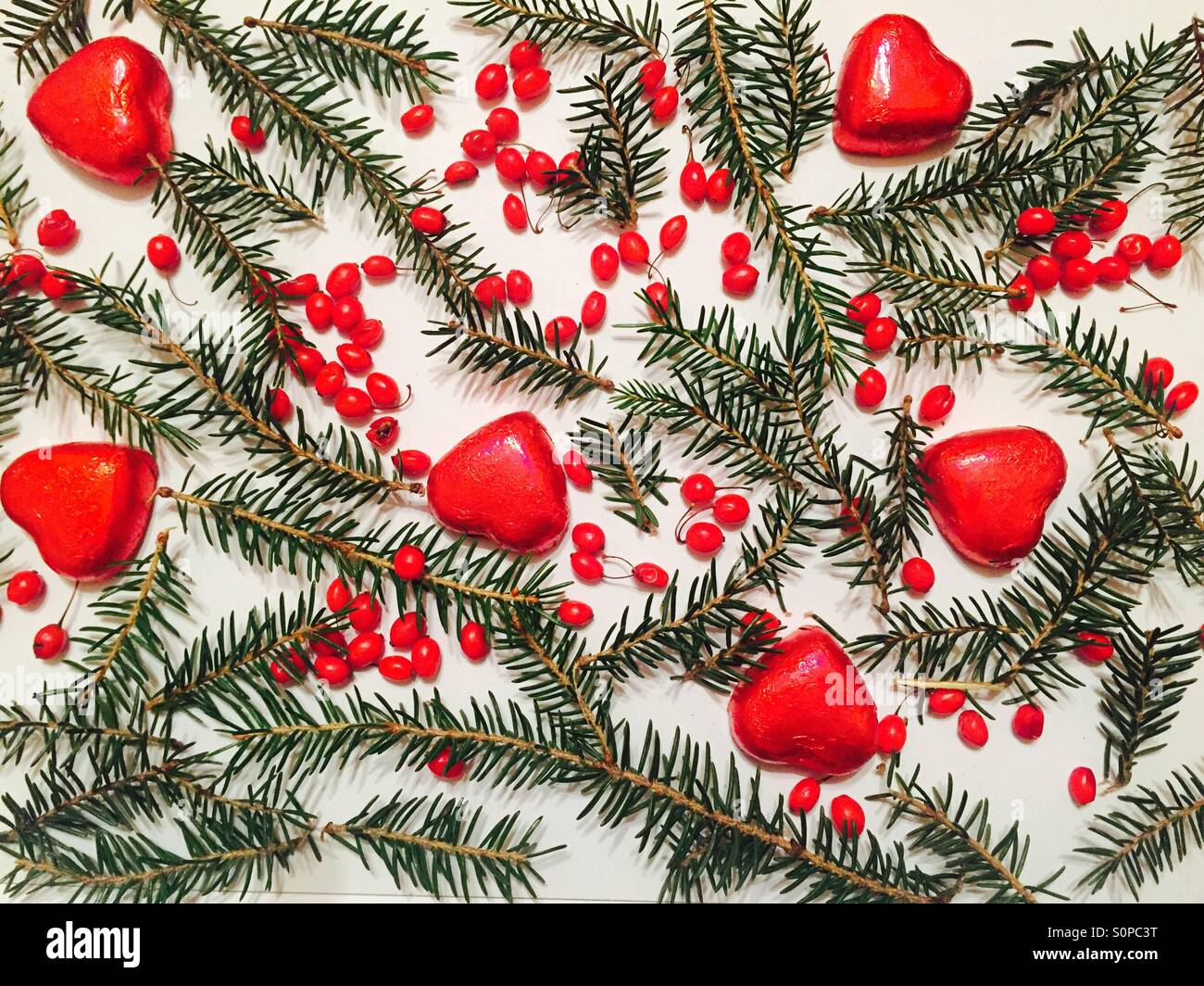 Il Cioccolato cuori,frutti rossi e di Natale a rami di alberi Foto Stock