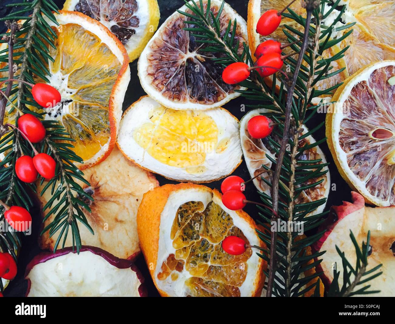 Arance essiccate con albero di Natale rami e frutti rossi Foto Stock