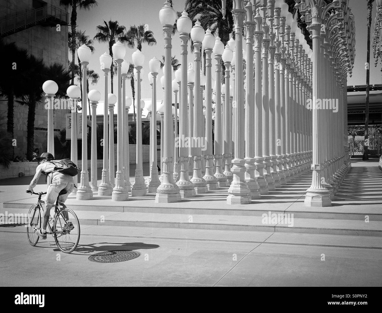 Ciclista in posa di fronte urbano di luce a LACMA Foto Stock