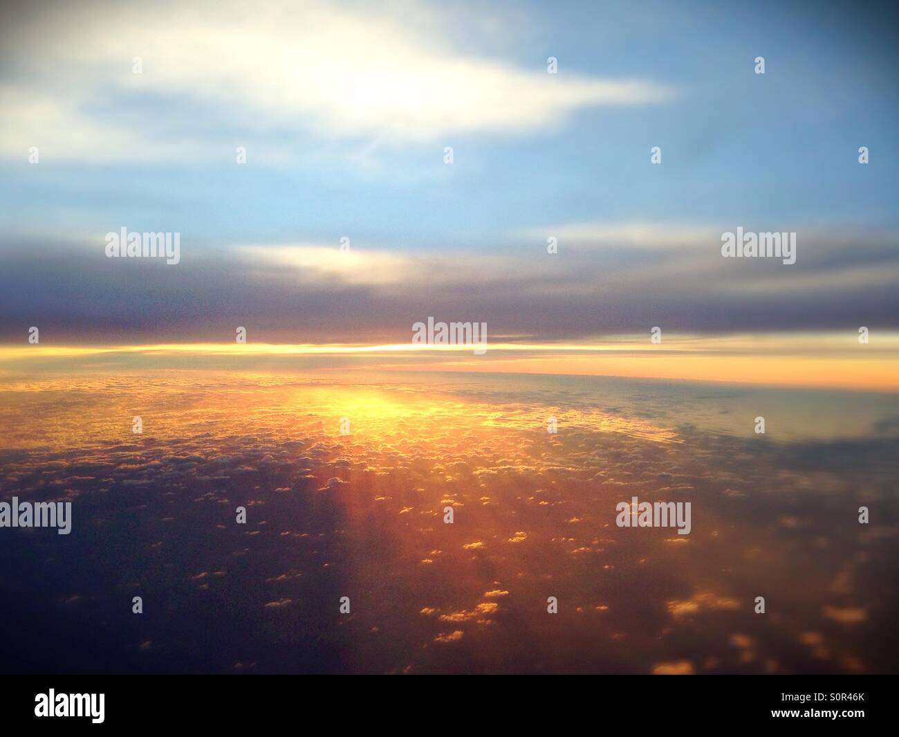 Un tramonto su puffy nuvole, come visto da un aeroplano. Foto Stock