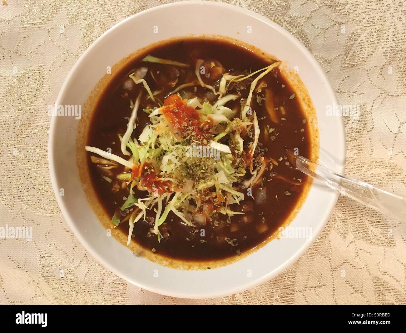 Ciotola di tradizionale Pozole messicano, un tradizionale rosso cile stufato piccante fatta con hominy e carni bovine. Di solito serviti per occasioni speciali ed è detto di essere una sbornia Remedy. Foto Stock