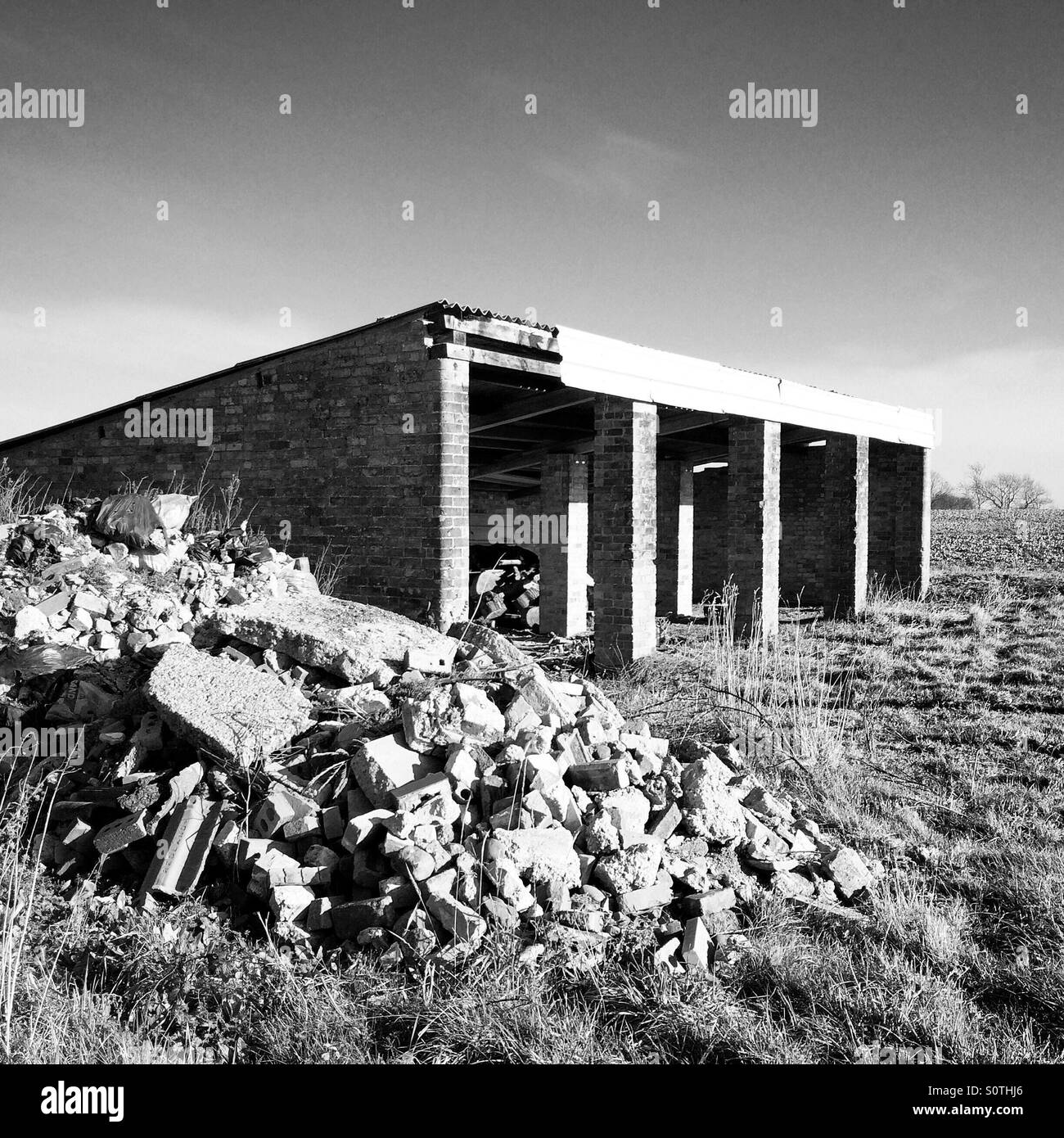 Abbandonato edificio agricolo e rifiuti di materiale di costruzione. Foto Stock