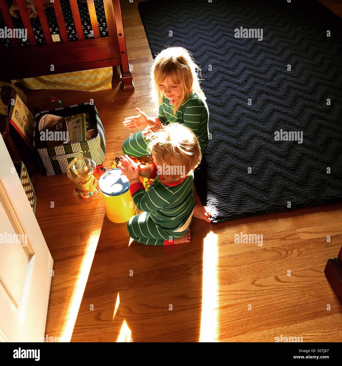 Mattina playtime tra fratello e sorella in pigiama da corrispondenti Foto Stock
