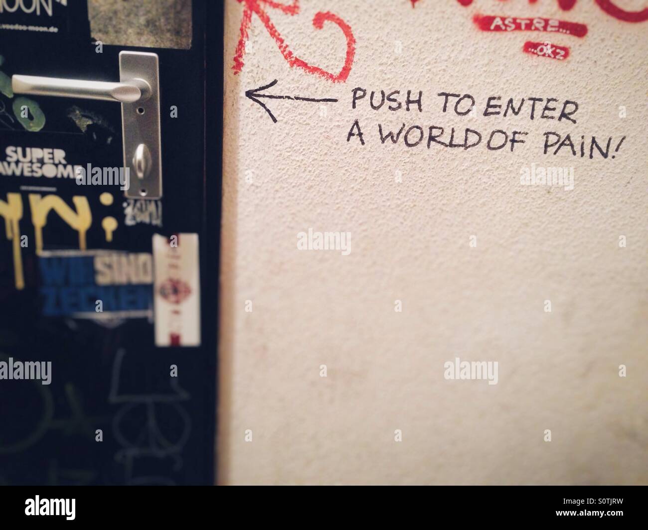 Graffiti in una toilette stallo in un bar di dire spingere per entrare in un mondo di dolore - Immagine stock catturata con smartphone