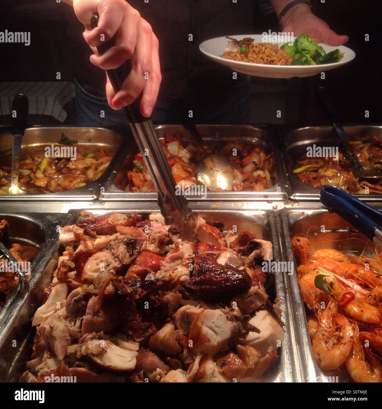 Londra, Regno Unito. 4 febbraio 2016. Un cliente riempie il loro piatto in un tutto quello che potete mangiare a buffet a Chinatown. Foto Stock
