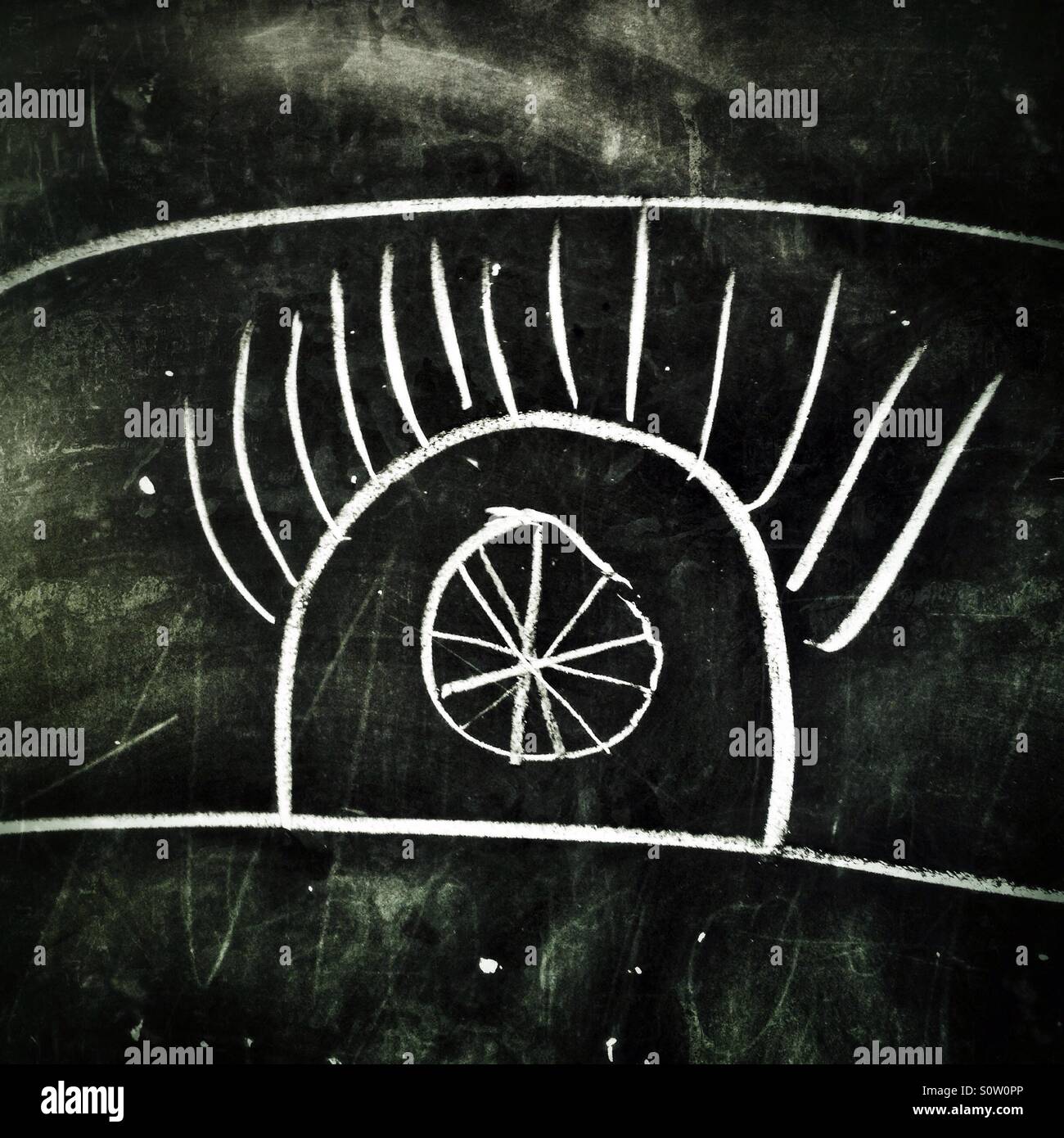 Un ingenuo studente di disegno un all-seeing eye su una lavagna a scuola Foto Stock