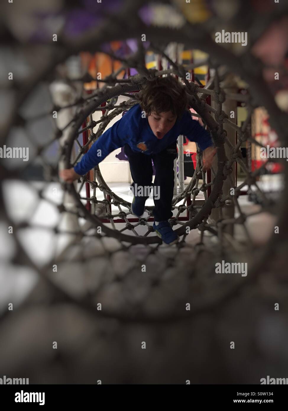 Kid giocando in corda di tunnel - Immagine stock catturata con smartphone