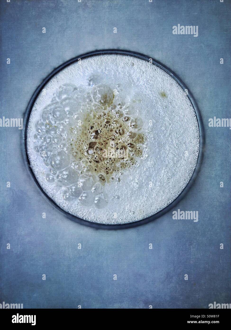 Di schiuma di latte del caffè su sfondo blu, presa da sopra Foto Stock