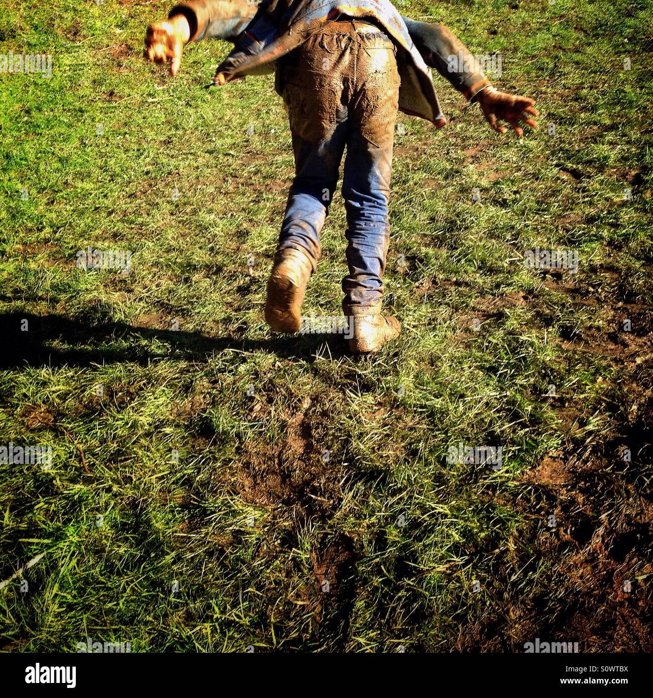 Ragazzo fangoso esecuzione di distanza Foto Stock