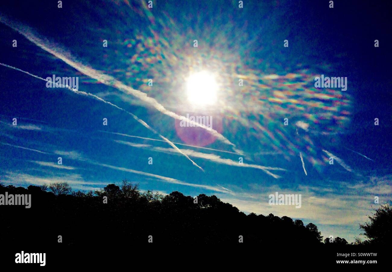 Sole di mattina illuminante contrails jetliner, Jacksonville, Florida, Marzo 2016 - Immagine stock catturata con smartphone