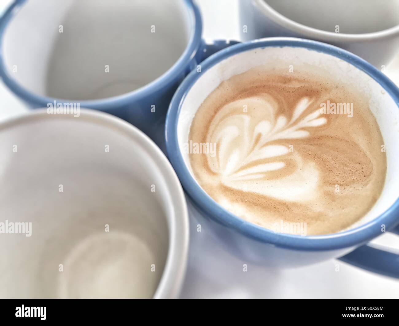 Tazza di latte accanto a bicchieri vuoti - Immagine stock catturata con smartphone