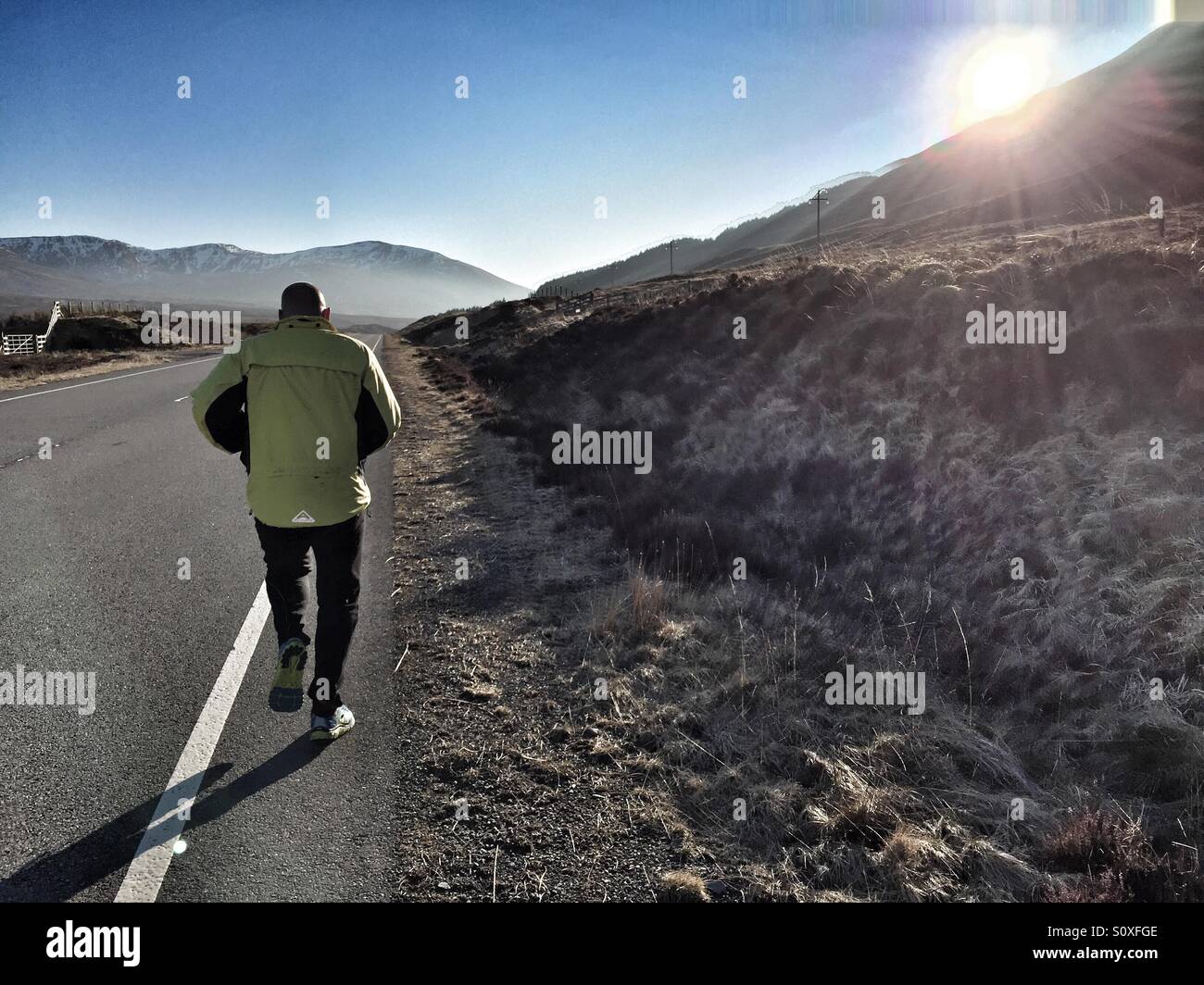 La libertà della strada aperta. 40 anno vecchio in esecuzione su una strada di montagna Foto Stock