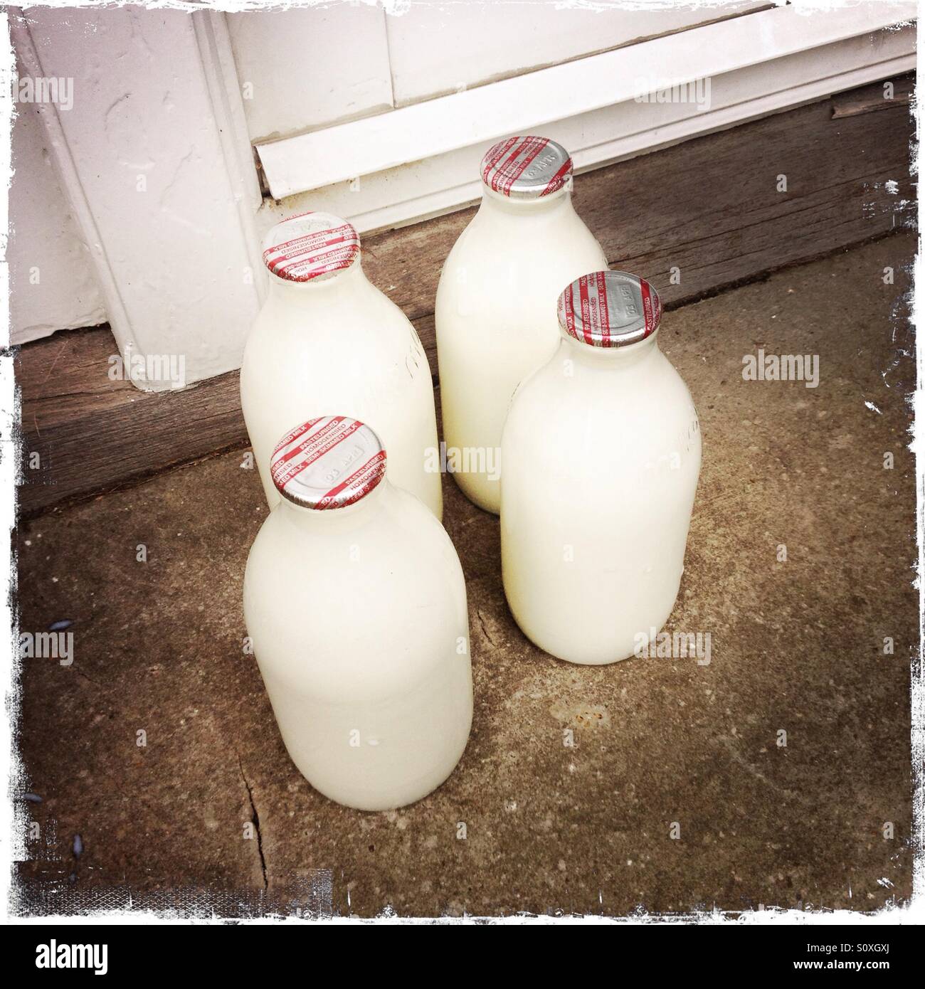 4 pinte di latte su una porta. Foto Stock