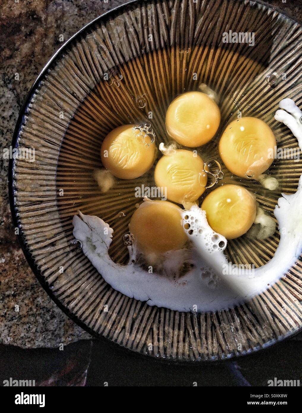 Le uova in una terrina in attesa di essere miscelati Foto Stock