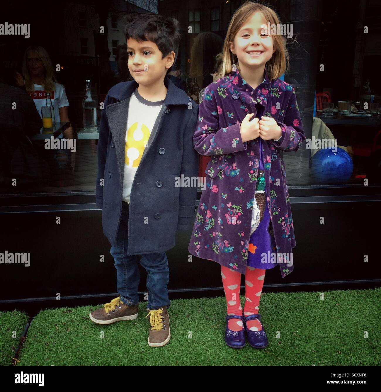 Un ragazzo e una ragazza modello il loro nuovo giacche nella zona ovest di Londra Foto Stock
