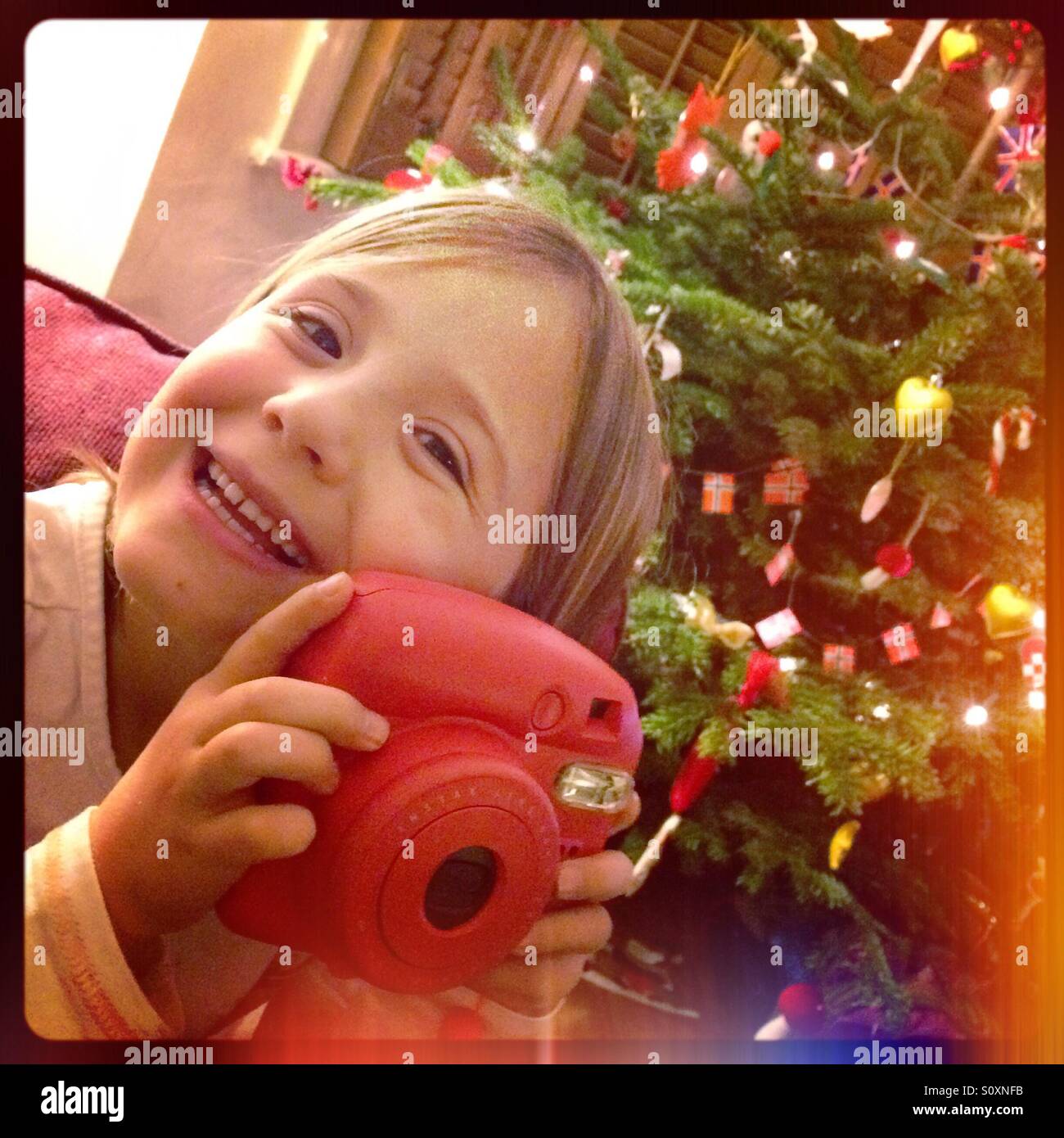 Albero Di Natale Con Foto Polaroid.Una Giovane Ragazza Pone Con Una Fotocamera Polaroid A Natale A Londra Foto Stock Alamy