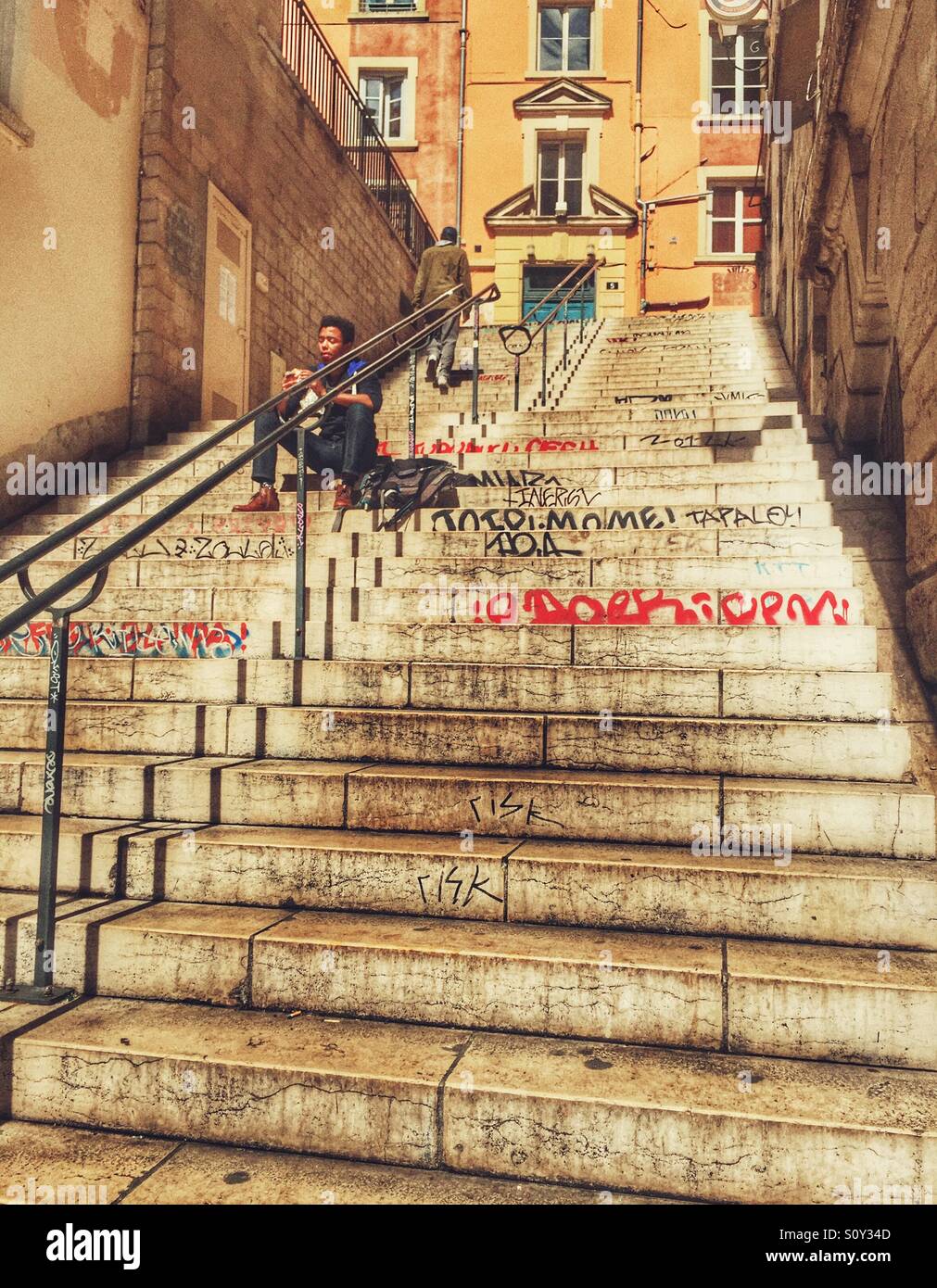 L'uomo mangiare sulle scale Lyon Francia - Immagine stock catturata con smartphone