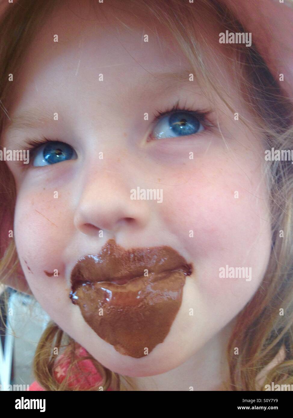 Quattro-anno-vecchia ragazza bambino kid bambini con marrone cioccolato gelato sul viso Foto Stock