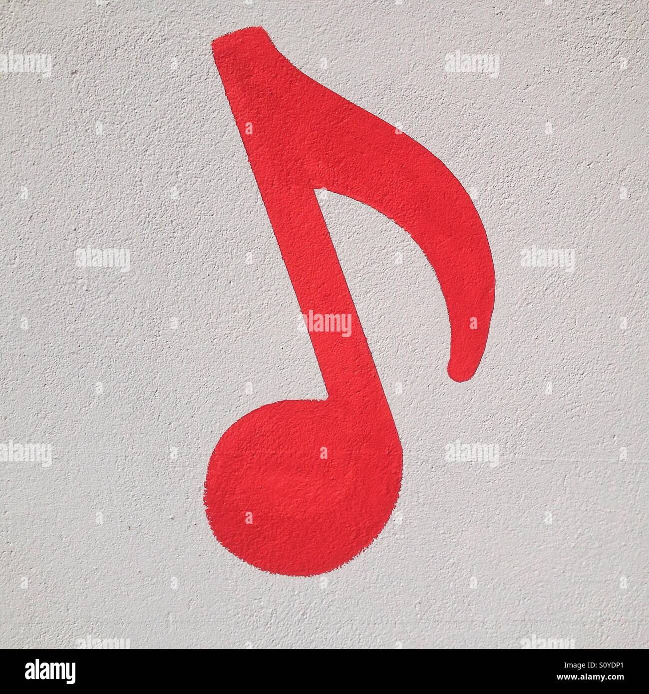 Rosso nota musicale dipinta su un muro bianco Foto Stock