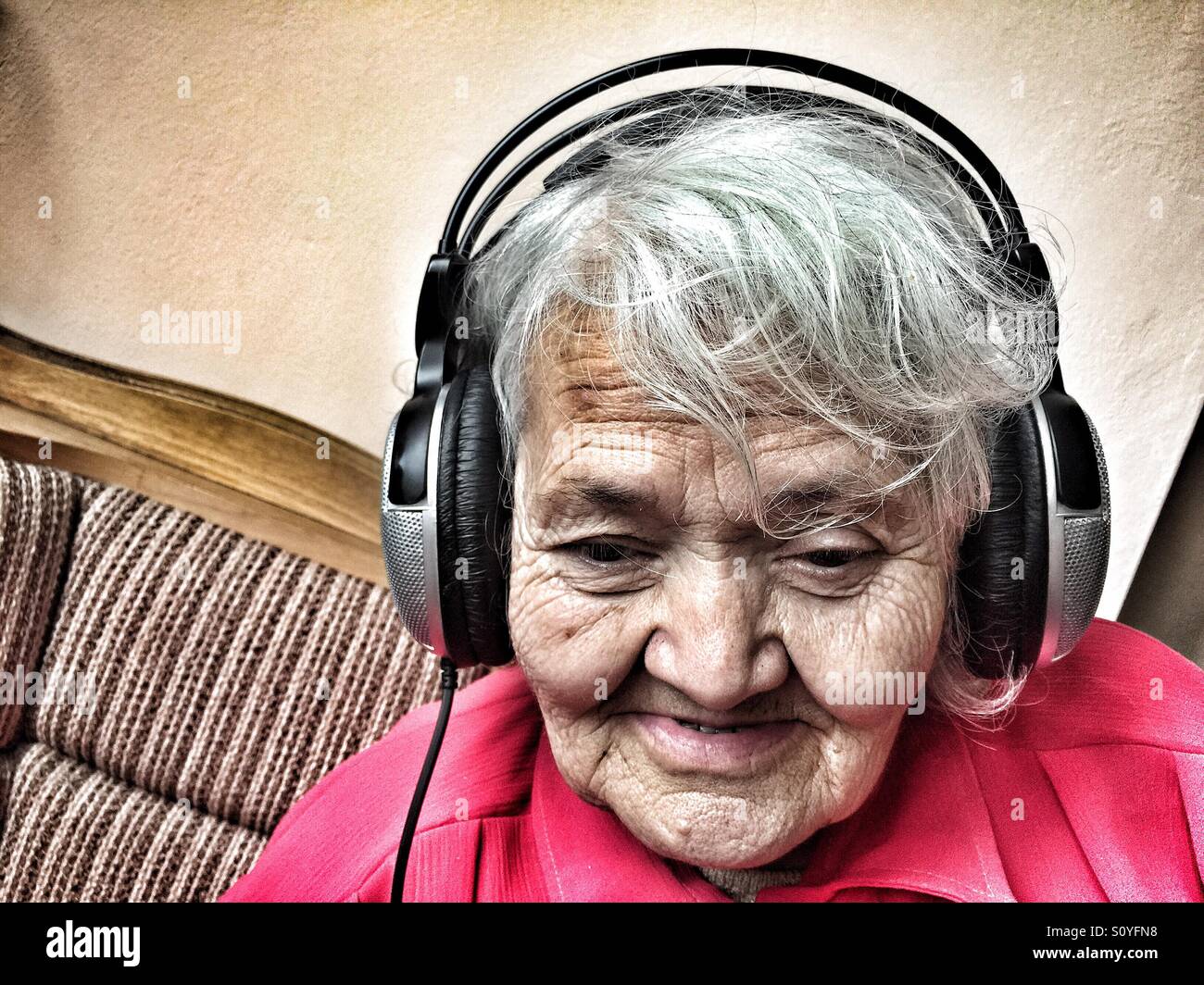 Donna anziana con le cuffie per ascoltare musica Foto stock - Alamy