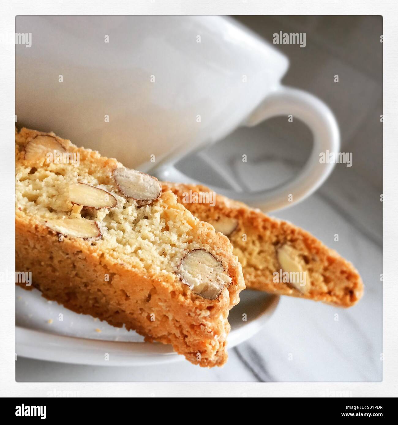 White tazza da caffè con piattino con tradizionale home italiano cotto biscotti biscotti. - Immagine stock catturata con smartphone