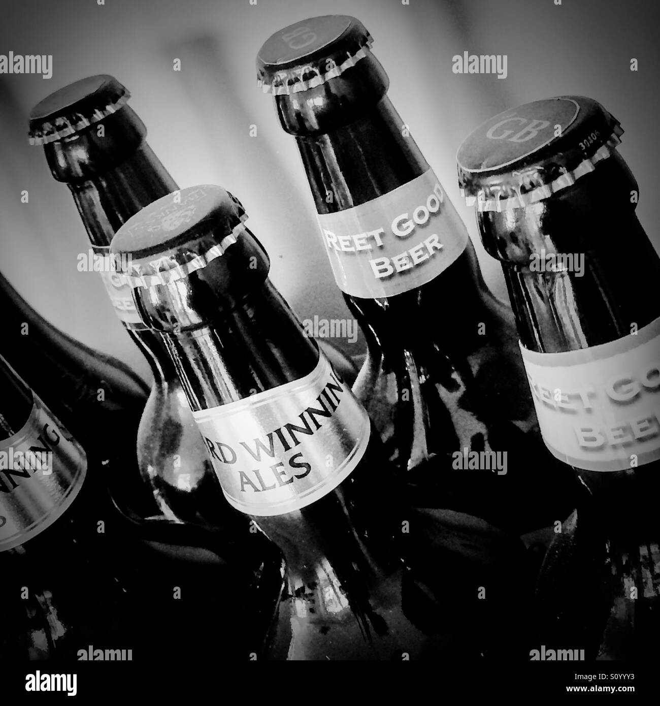 Fotografia in bianco e nero dei colli e cime di bottiglie di birra Foto Stock