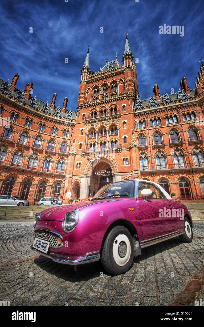 Un classico, viola l'auto di fronte al St Pancras Hotel in Londra, Regno Unito. Auto classica di fronte di bella architettura gotica. Foto Stock