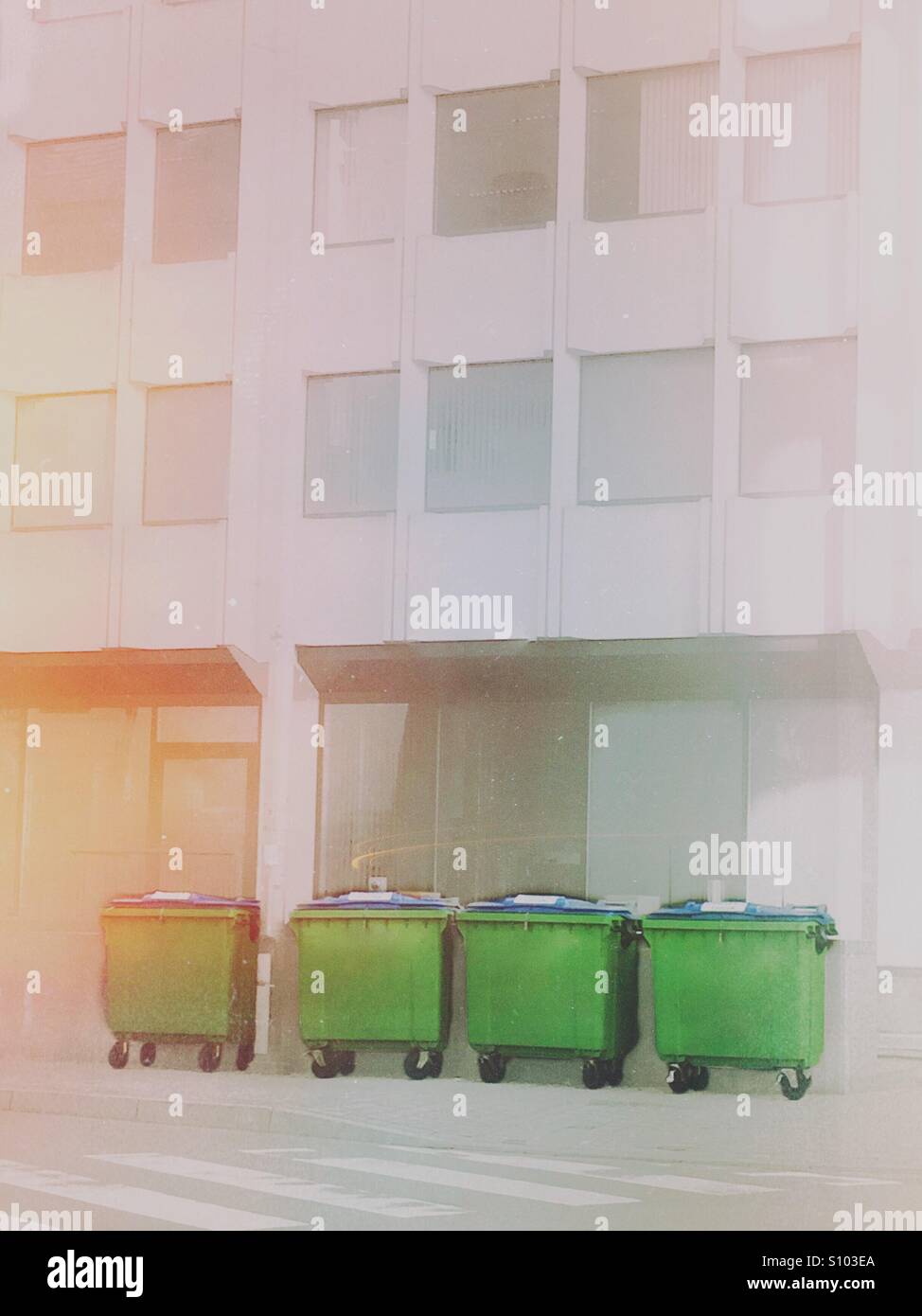 4 contenitori per rifiuti di fronte ad un edificio per uffici - Immagine stock catturata con smartphone