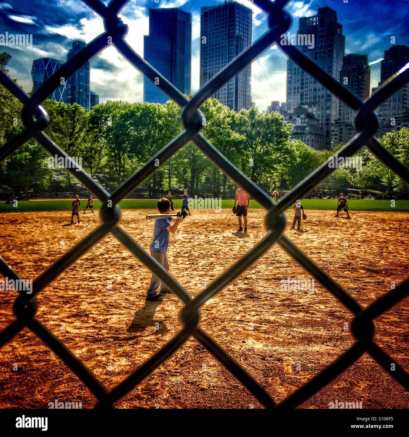 I bambini a giocare a baseball nel Central Park di New York Foto Stock