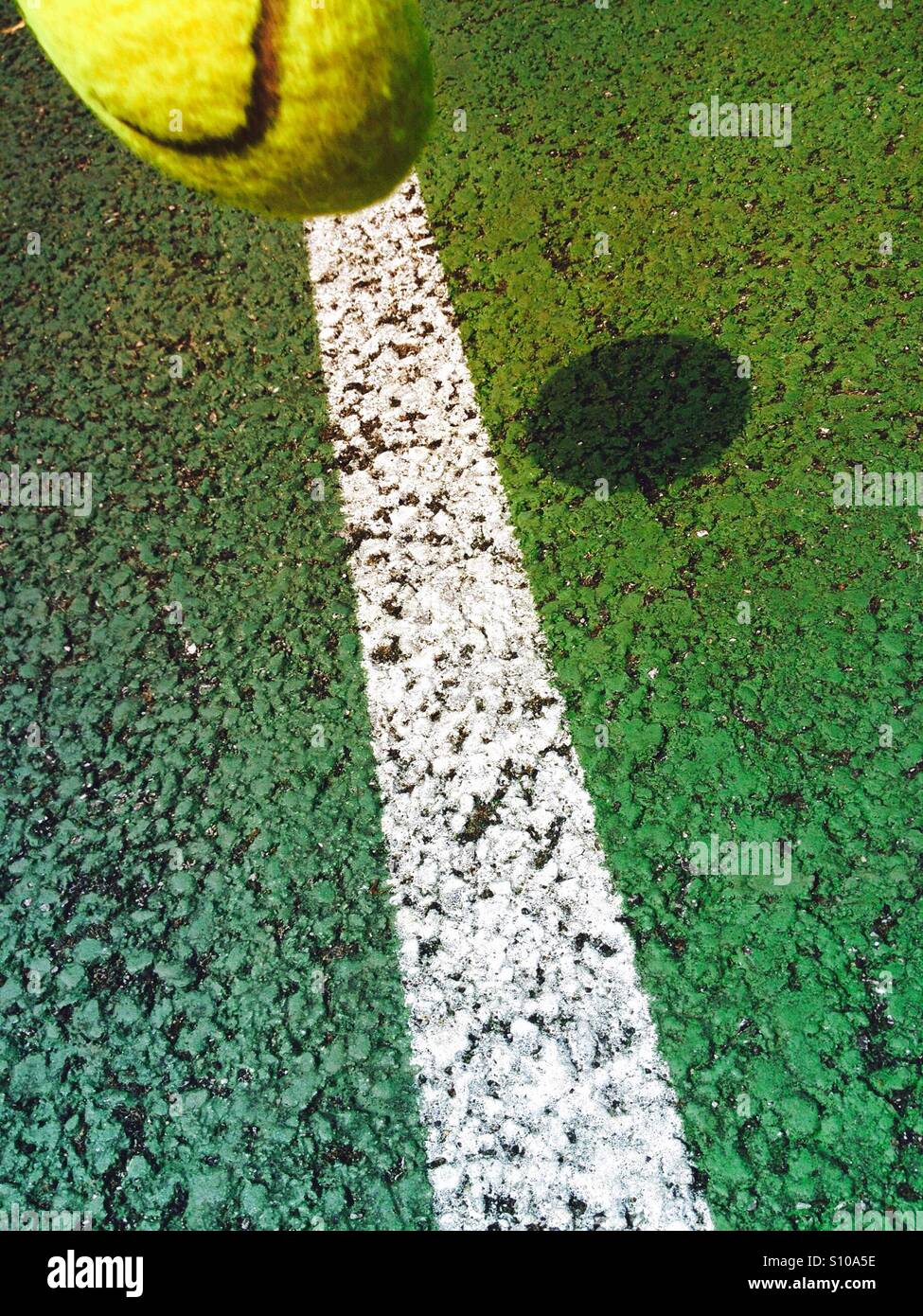 Spostando palla da tennis circa a cadere sulla linea di un campo da tennis Foto Stock