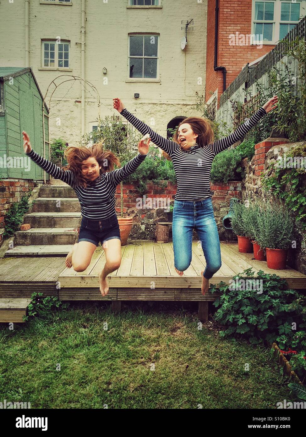 Due ragazze di saltare in un giardino Foto Stock
