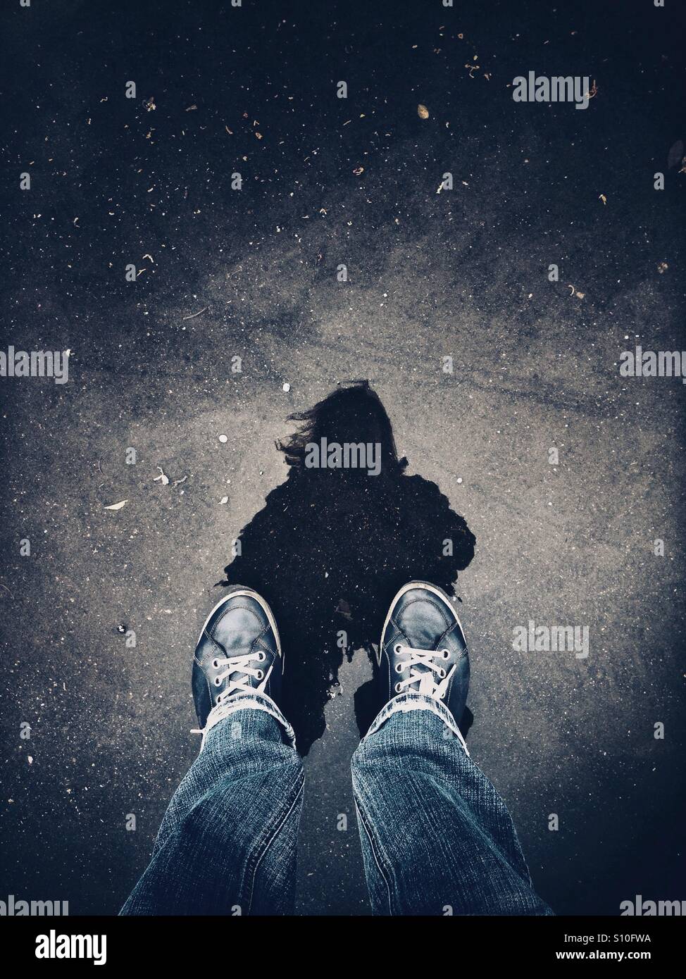 Classifica le gambe in una pozzanghera con silhouette a riflessione - Immagine stock catturata con smartphone