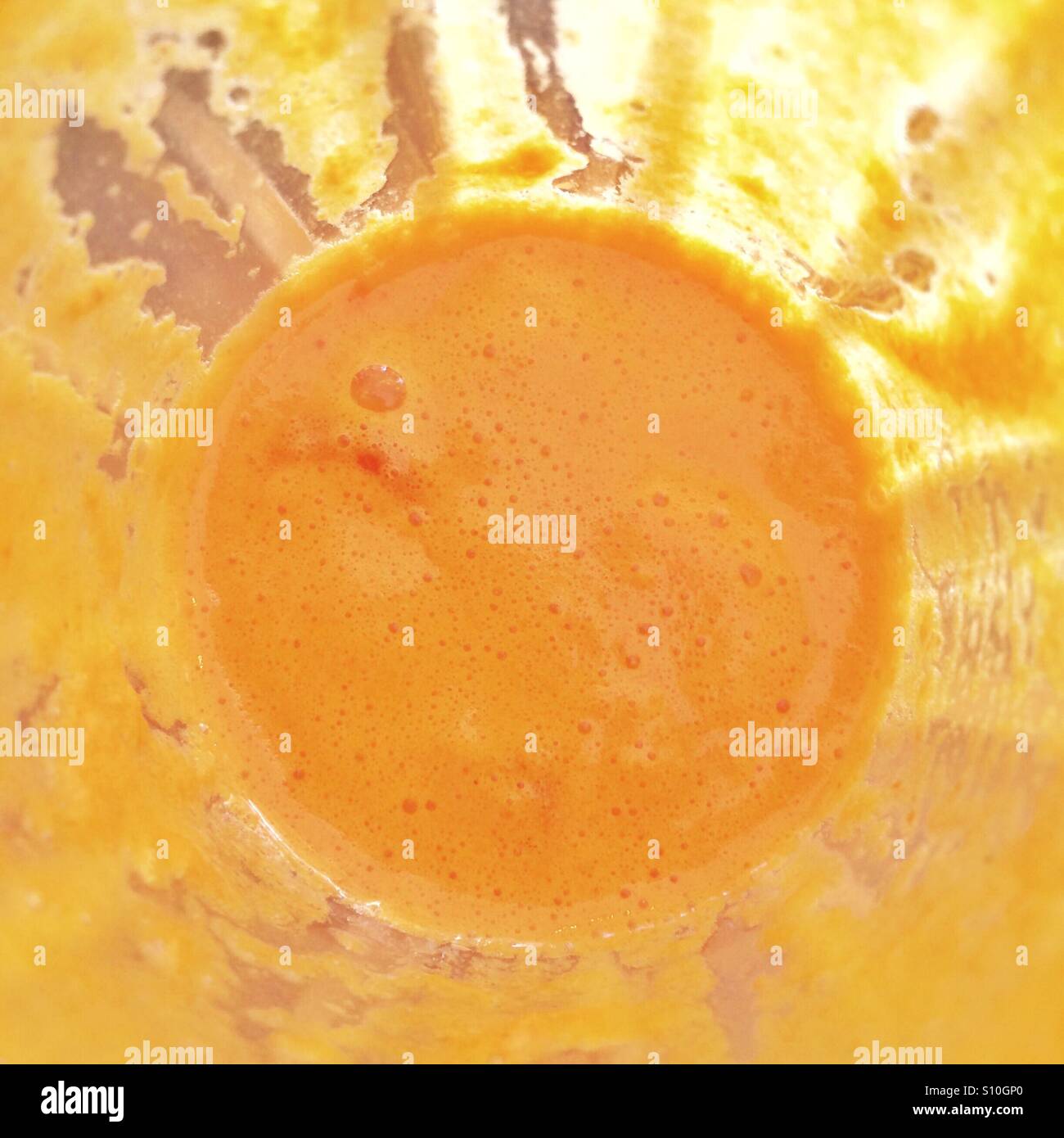 Il sole in un fondo di un vetro di succo d'arancia Foto Stock