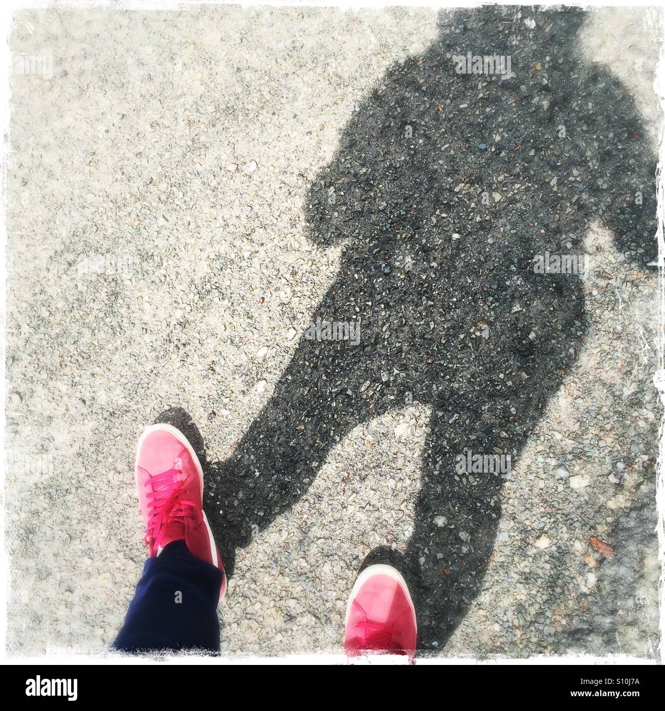 Scarpe rosso con ombra umana Foto Stock