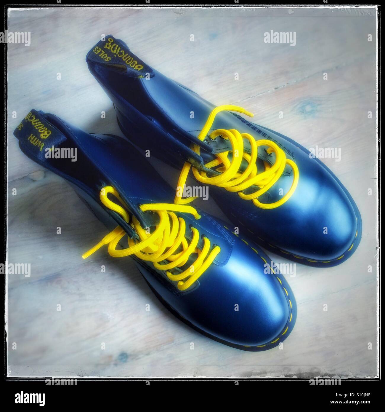 Coppia di Dr Martens design classico stivali in pelle blu con lacci di colore giallo Foto Stock
