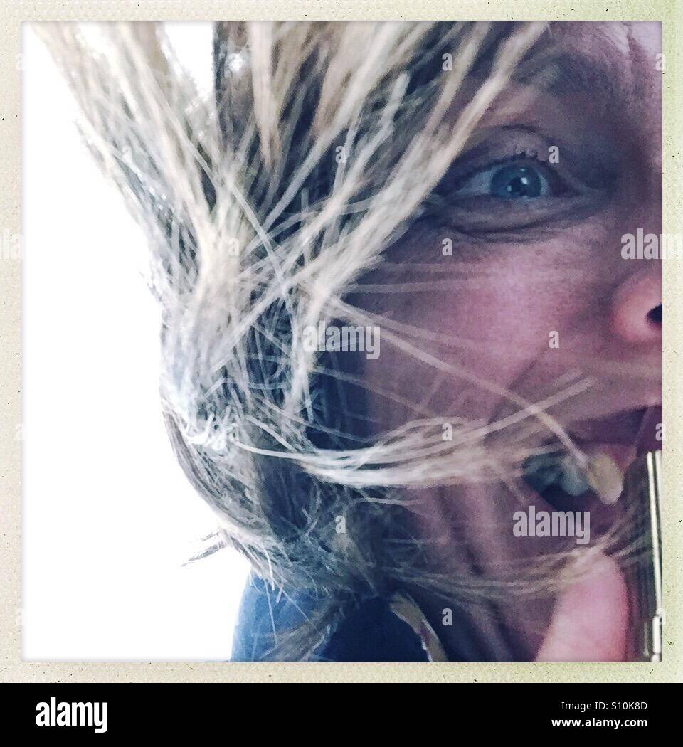 Selfie mettendo il rossetto con volare lontano i capelli Foto Stock