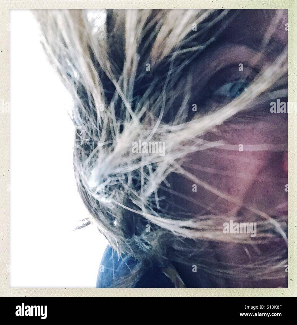 Selfie di metà di un volto di donna con volare lontano i capelli Foto Stock