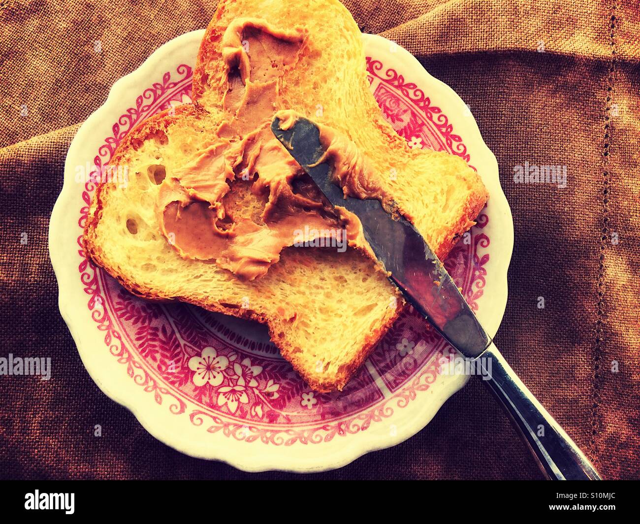 Diffusione di burro di arachidi su pane tostato Foto Stock