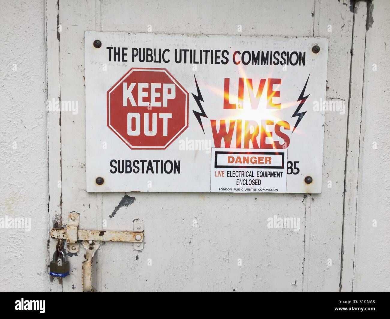 Cavi sotto tensione e apparecchiature elettriche racchiuse in una sottostazione pubblica di servizi pubblici, Ontario, Canada. Involucro, pericolo, Vietato entrare. Attenzione. Avvertenza. Arrestare il pittogramma. - Immagine stock catturata con smartphone