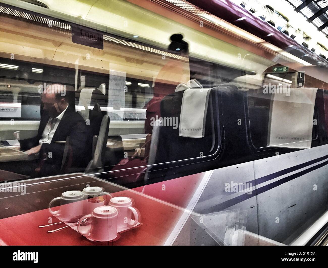 Riflessioni del passeggero e tazze in windows, Vergine treno prima classe coach Foto Stock