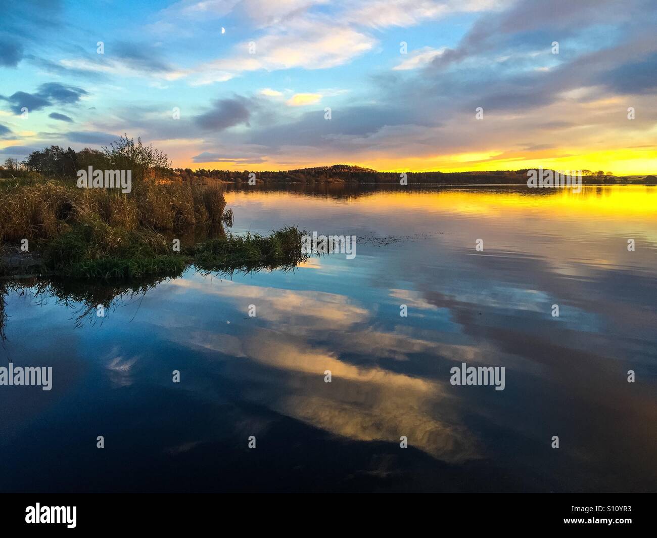 Tramonto Dorato sulle rive di Loch Foto Stock