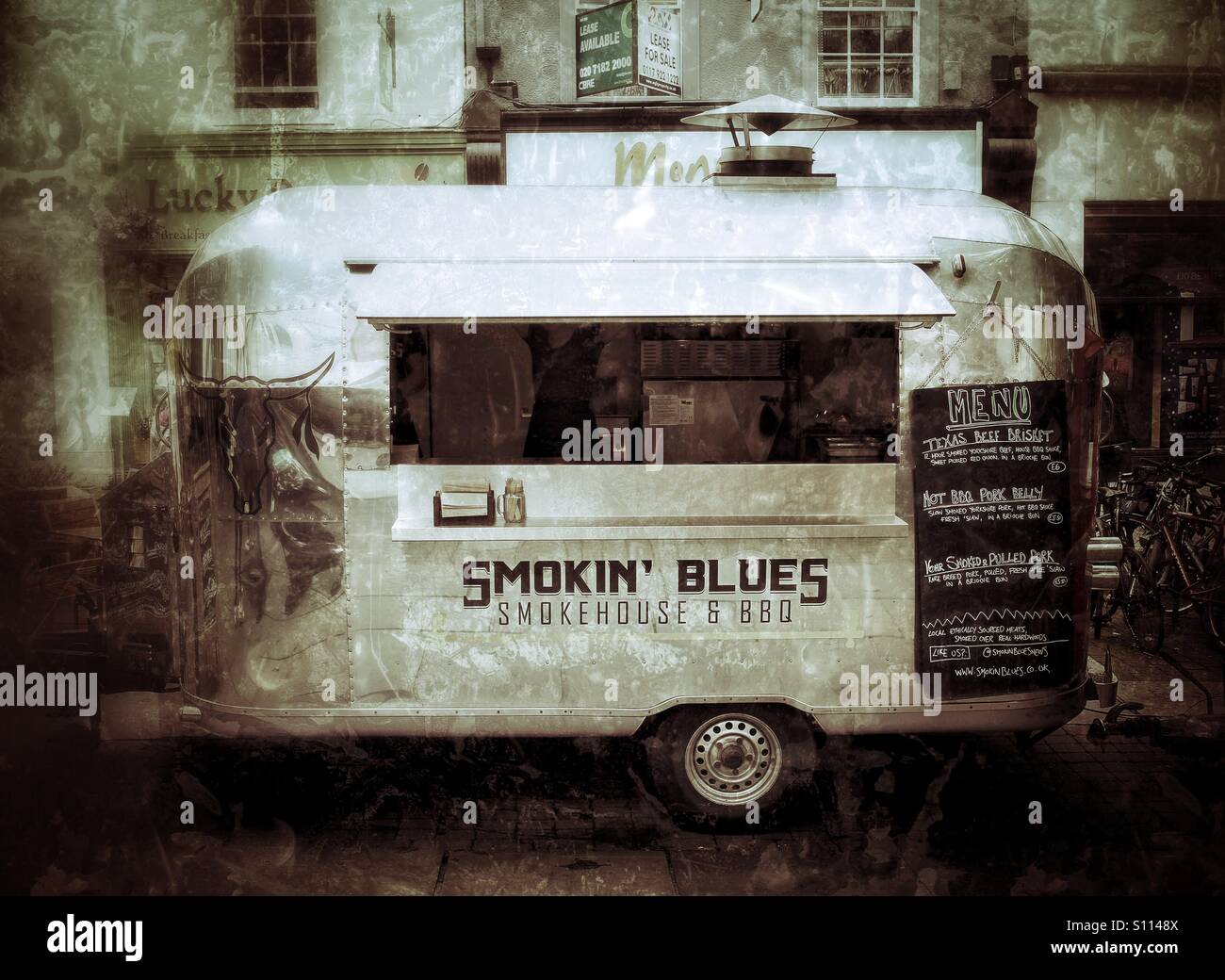 Un barbecue van o grill con un lucido, argento esterno la vendita di cibo di strada nelle strade della città in un mercato alimentare. - Immagine stock catturata con smartphone